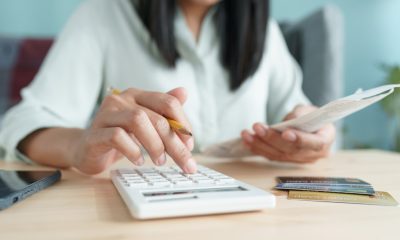 Closeup of a woman calculating bills and debts, considering getting a 1-month loan